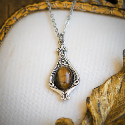 Antiqued silver vintage inspired small vanilla girl aesthetic necklace with a dainty brown tiger eye stone on a mini floral drop setting.