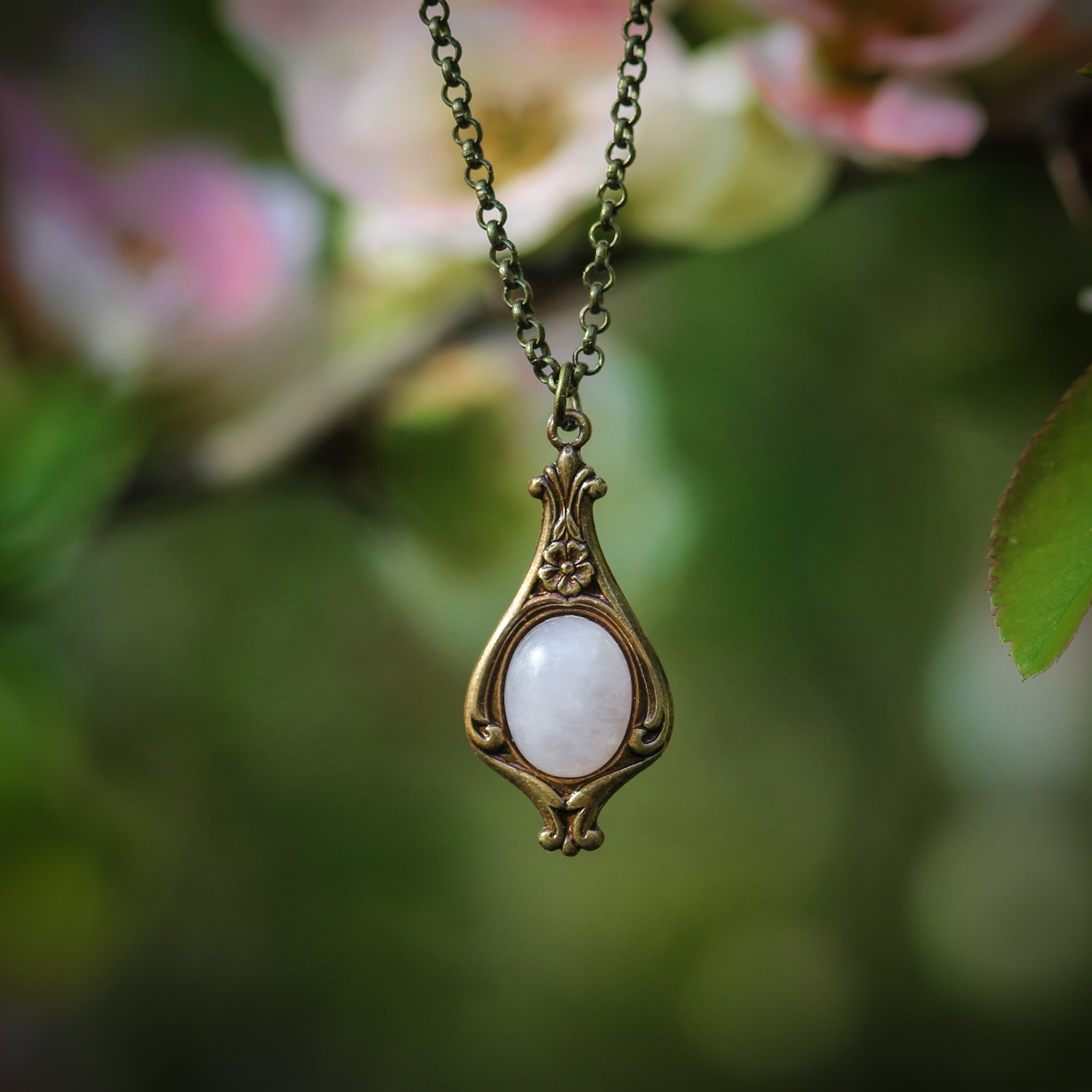 Antiqued brass vintage-inspired small lolita aesthetic necklace with a dainty pink rose quartz stone on a mini floral drop setting.