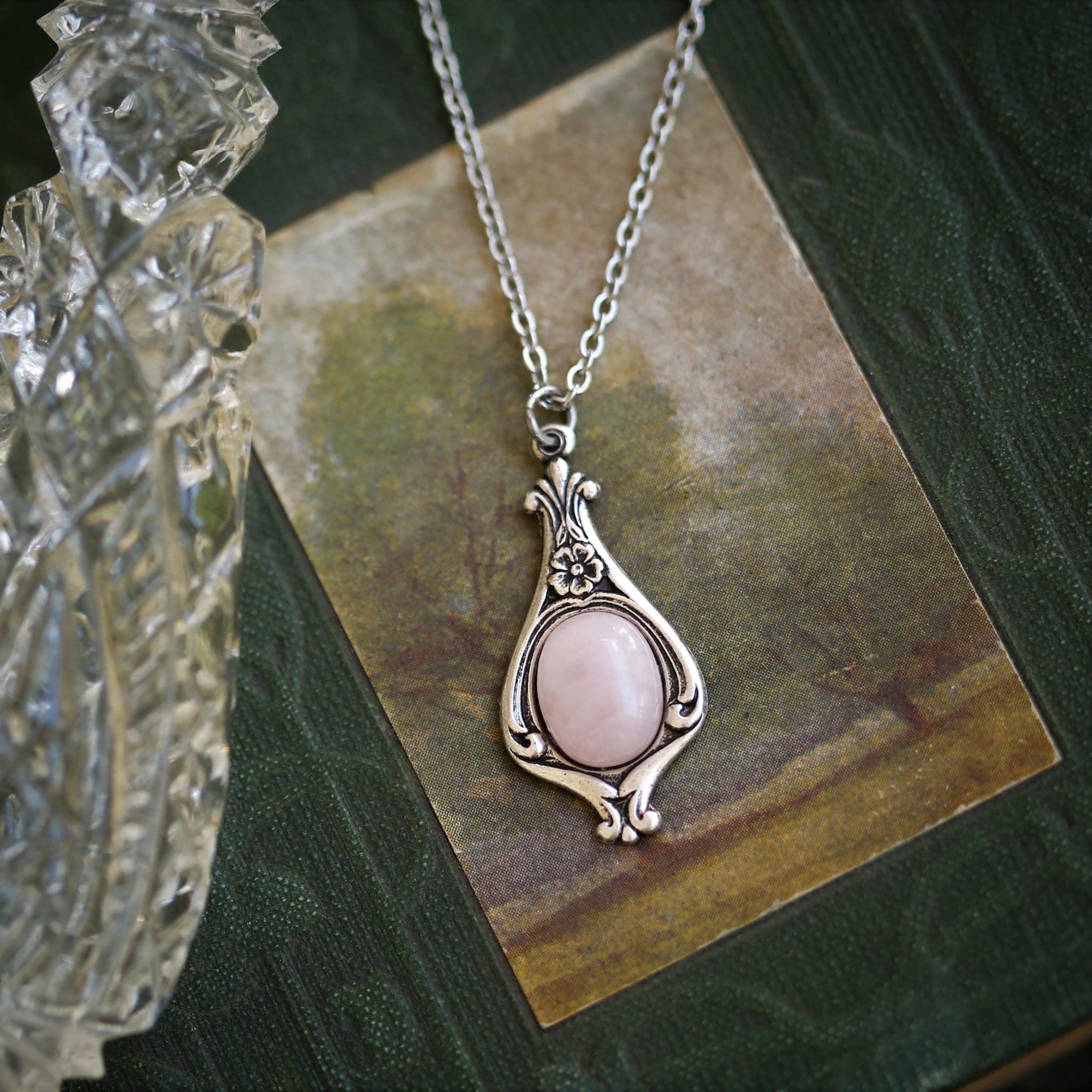 Antiqued silver vintage-inspired small clean girl aesthetic necklace with a dainty pink rose quartz stone on a mini floral drop setting.