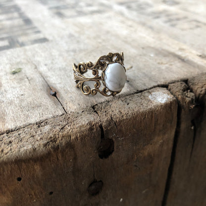 rich bronze colored antiqued brass modern vintage inspired adjustable filigree ring with a white marble howlite semi-precious mineral oval stone in the vanilla girl aesthetic
