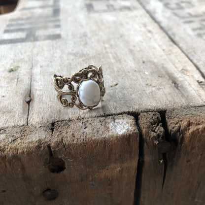 rich bronze colored antiqued brass modern vintage inspired adjustable filigree ring with a white marble howlite semi-precious mineral oval stone in the witchy aesthetic
