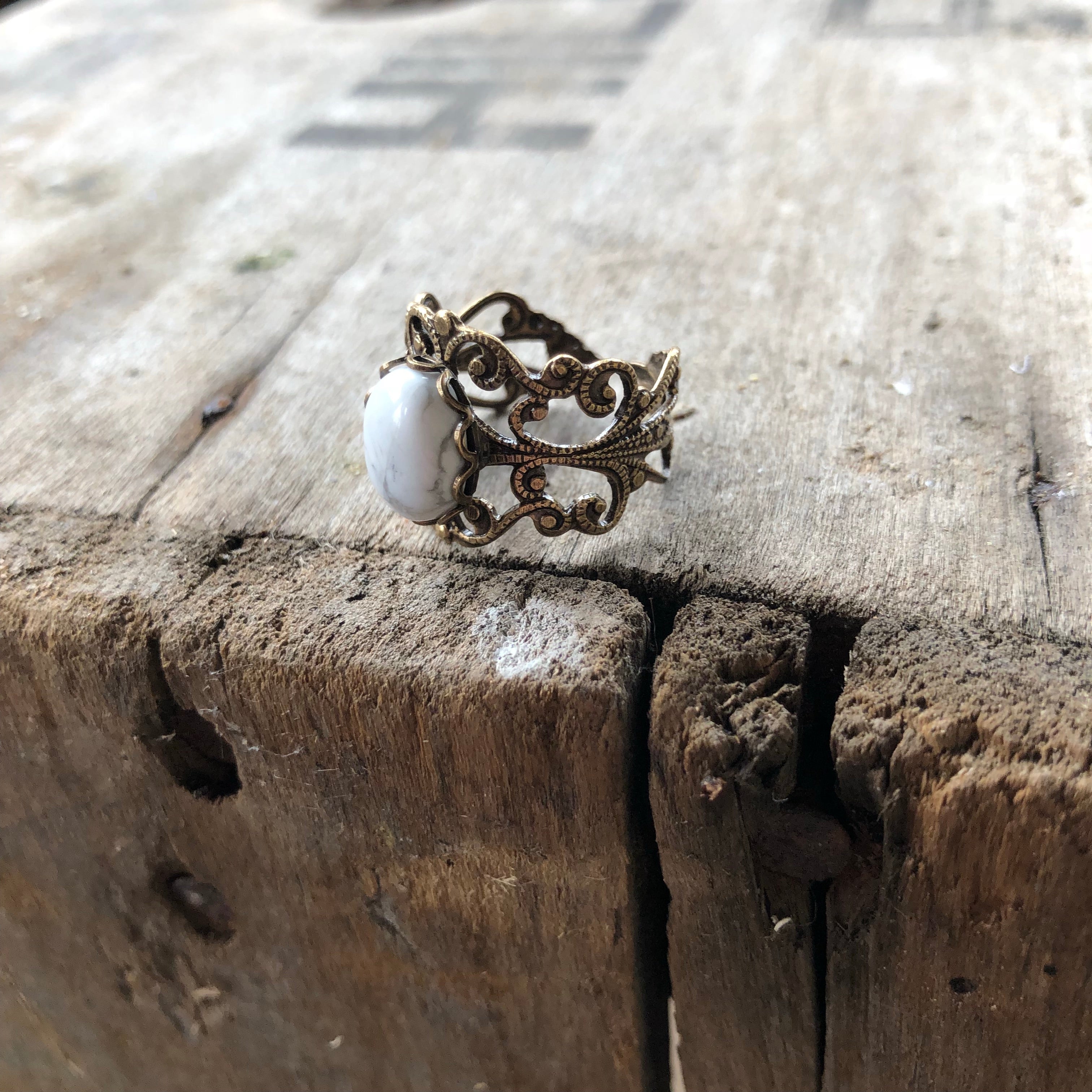 rich bronze colored antiqued brass modern vintage inspired adjustable filigree ring with a white marble howlite semi-precious mineral oval stone in the winter fairy aesthetic
