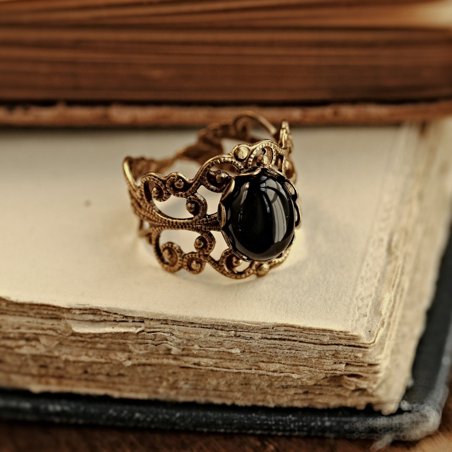 Antiqued silver modern vintage inspired adjustable filigree statement ring with a black oval onyx semi-precious stone mineral cabochon in dark academia style the stone of the leo zodiac