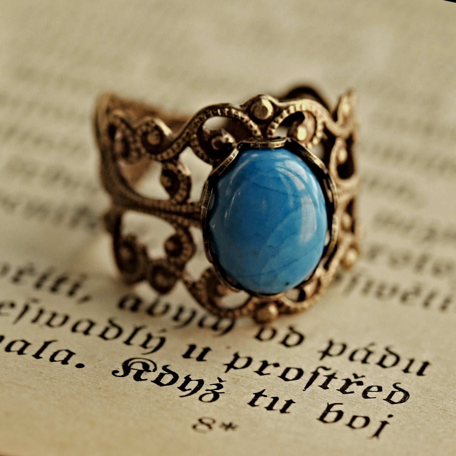 antiqued brass modern vintage inspired resizeable filigree statement ring with a turquoise blue howlite oval semi-precious mineral stone in the acubi fashion aesthetic.